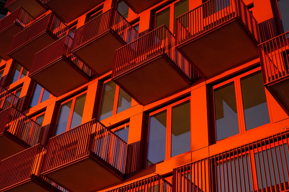 Red-orange balconies and railings on an apartment building