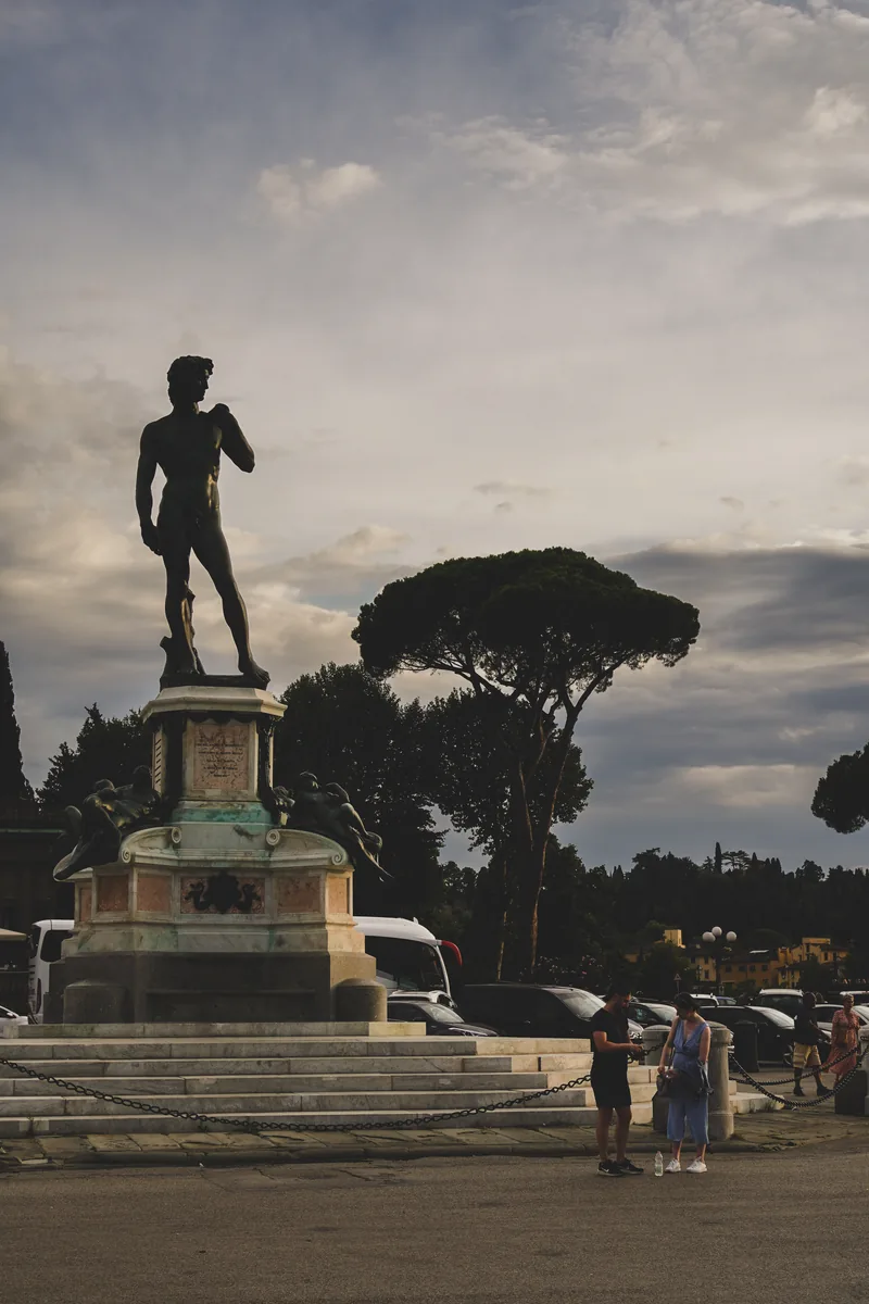 A bronze statue on a pedestal against a cloudy sky