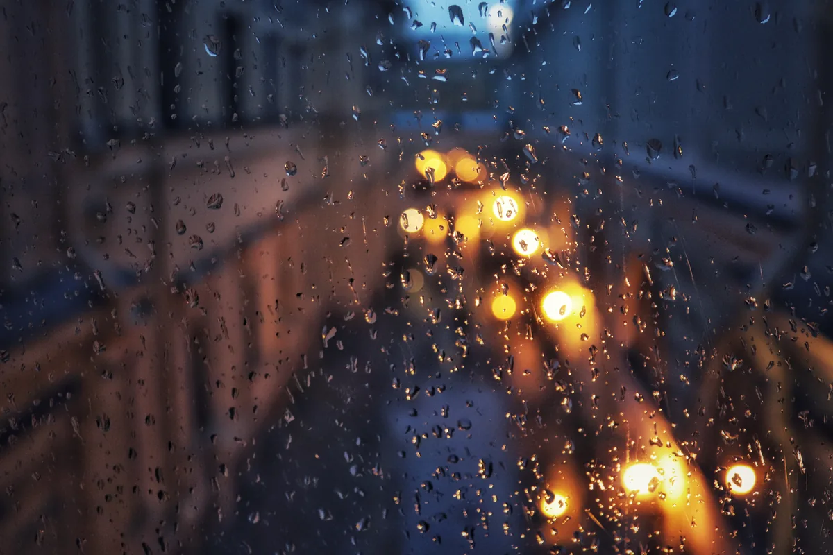 City lights blurred through a rain-spotted window